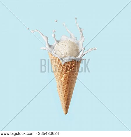 Waffle corn of fresh natural homemade sweet ice-cream with milk splash against light blue background, copy space. Healthy natural dessert.