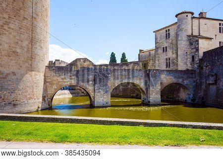  Powerful medieval walls and a moat with water surround the ancient city of Aigues-Mortes. Mediterranean coast of France. The concept of active, historical and photo tourism