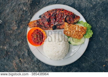 Delicious Grilled Tilapia (nila Bakar) From Indonesia With Rice, Tempeh, Vegetables, And Chilli Sauc