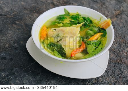 Gurame Fish Head Soup Or Sup Kepala Ikan Gurame With Basil Leaves, Tomatoes, Yellow Curry, And Chill