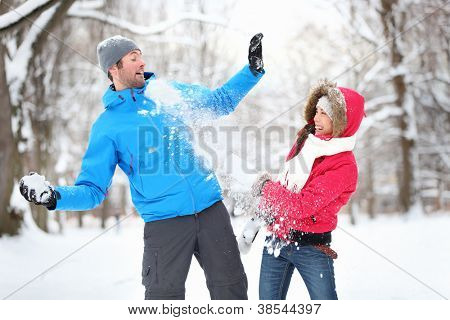 Sorgenlos happy young Couple Spaß zusammen im Schnee im Winter Wald werfen Schneebälle auf eac