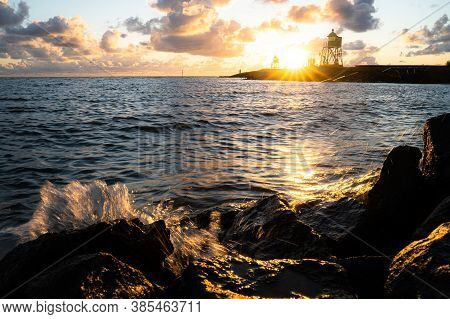 Green And Red Lighthouse Of The Harbor Entrance Of Stavoren, Netherlands, Photographed At Sunset And