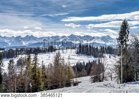Panoramic View On Snowy Forest And Tatra Mountains In Winter Time. Ski Slopes And Ski Lifts In Bialk