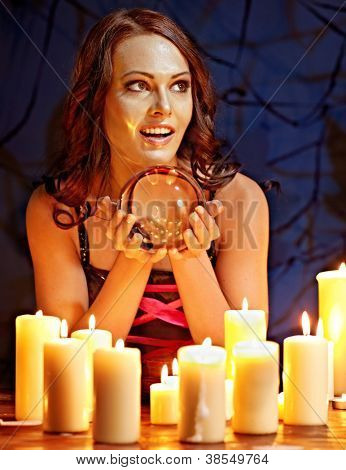 여 자가 scrying 공과 촛불 들고입니다.