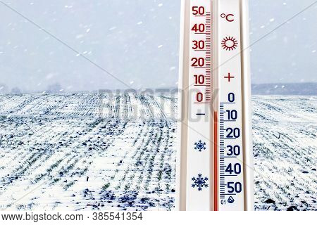 The Thermometer On The Background Of The Field During The Snowfall Shows 5 Degrees Below Zero