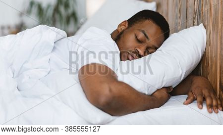 African American Man Sleeping Hugging Pillow Resting Lying With Eyes Closed In Comfortable Bed In Be