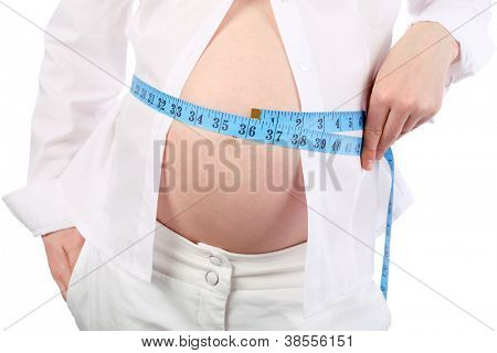 Břicho těhotné ženy v bílém, měření břiše modré centimetr pásky izolovaných na bílém poza