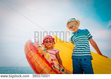 Happy Boy And Girl With Floaties On Beach Vacation