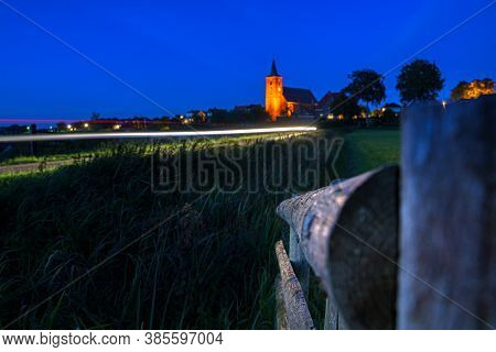 Medieval Church In The Floodplains On A Dike Of A Dutch River Landscape