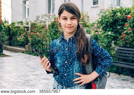 Smiling Little Schoolgirl Girl With Laptop In Hand, Back To School And Successful Female Career Conc