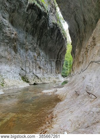 Cheile Rametului Gorges Wild Natural Park River Area. Waterfall On Small River In Dense Forest In Al