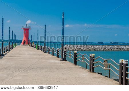 Seosan-si, South Korea; August 28, 2020: For Editorial Use Only. Red Lighthouse On End Of Ocean Quay