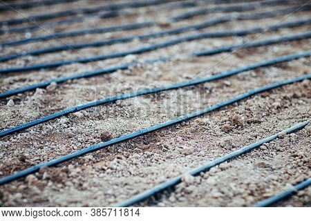 Irrigation System On The Plot. The Hose Is Laid Out On The Ground And Ready For Watering. Horizontal