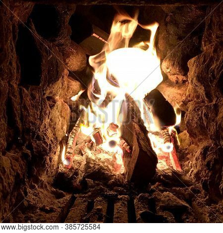 Beautiful Red Fire From Slice Wood, Dark Grey Black Coals Inside Metal Brazier. Wood Burning In The 