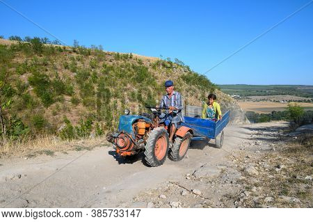Socola village, Soldanesti, Moldova, September 2020: Mini tractor at mountain road iwith passenger. This mode of working transport bacomes popular at bad roads in this region.