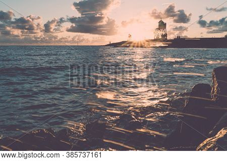 Green And Red Lighthouse Of The Harbor Entrance Of Stavoren, Netherlands, Photographed At Sunset And