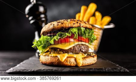 Tasty Humburger With Tomatoes And Cheese. Rustic Stone Background. Front View