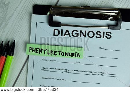 Diagnosis And Phenylketonuria Write On A Paperwork Isolated On Wooden Table.