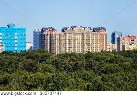 Above View Of Lush Green City Park And Rhigh-rise Apartment Houses On Horizon On Sunny September Day