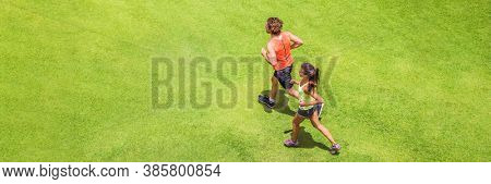 Runners running people couple fitness banner. Healthy active lifestyle. Active couple jogging together on grass park background textire top view from above panoramic banner.