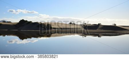 Dune Landscape And Blue Sky Reflected In The Water, Lagoon Of Maspalomas, Gran Canaria, Spain