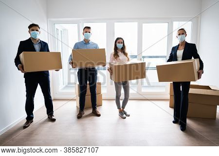 Office Relocation. Executives Moving Cardboard Boxes In Face Masks