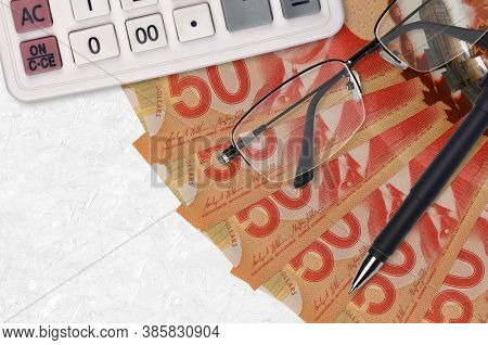 50 Canadian Dollars Bills Fan And Calculator With Glasses And Pen. Business Loan Or Tax Payment Seas