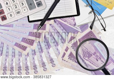 100 Philippine Piso Bills And Calculator With Glasses And Pen. Tax Payment Season Concept Or Investm