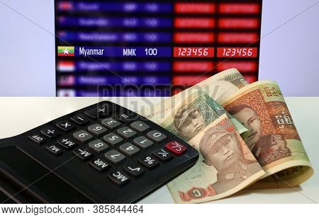 Pile Of Banknote Currency Myanmar Kyats With Calculator On The White Floor With Digital Board Of Cur