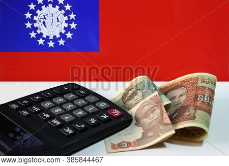 Pile Of Banknote Currency Myanmar Kyats With Calculator On The White Floor With The Obsolete Flag Of