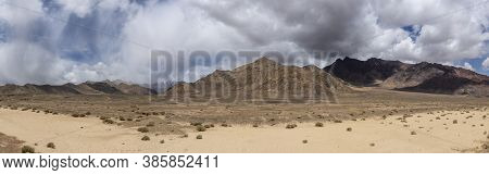 Panorama Of Bare Mountains In The Valley Of The River Murghab With Dark Rain Clouds Near The Village