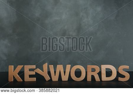 Word Keywords Made Of Wooden Letters On Dark Table. Space For Text