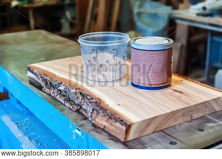 Epoxy Resin And Measuring Container In A Carpentry Shop. Making Furniture With Epoxy Resin