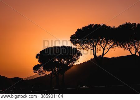 Scenic View Of Vibrant Orange And Pink Sky Picturesque Sunset On Highway With Cars Driving Around Mo