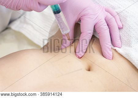 Lipolytic Injections Are Placed In The Stomach. Female Hands In Pink Gloves Inject A Young Woman Int