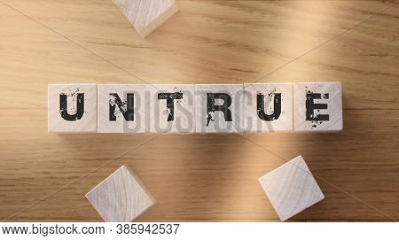 Untrue Word On Wooden Cubes. True And False Concept For Education And Business News
