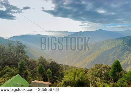 Green Valley Between Himalayan Mountain Slopes With Tree Lines In The Foreground, Shot With Morning 