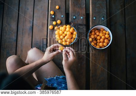 The Girl Processes Yellow Plums Before Making Jam.
