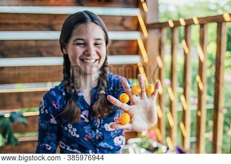 Young Girl Holding Yellow Fruits In Her Hands, Healthy Breakfast, Snack. Selective Focus