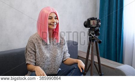 Young And Smart. Beautiful Young Woman With Pink Hair In Casual Wear While Recording Video Blod