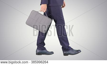 Handsome Businessman In A Suit Walks With A Briefcase On Gradien