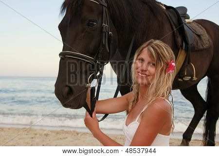 Pige med en hest ved havet