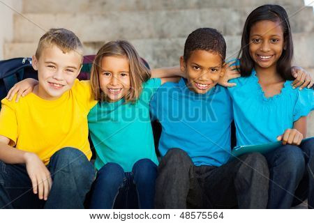 schöne Grundschüler sitzen im freien