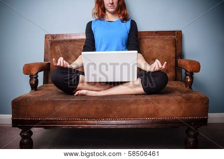 Spiritual Woman Sitting On Sofa Using Her Laptop