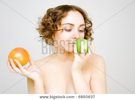 Hermosa chica elige entre una manzana o pomelo