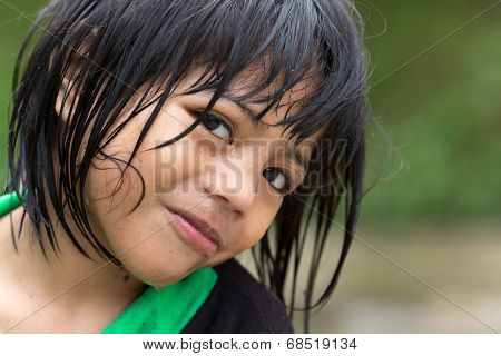 BANAUE, PHILIPPINES, DECEMBER 04, 2013: A young unidentified Filipino little girl is posing under the rain in the village of Banaue, north Luzon, Philippines
