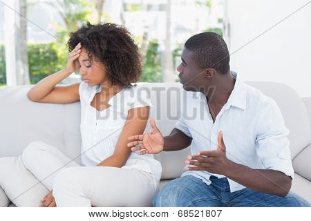 Attractive couple having an argument on couch at home in the living room