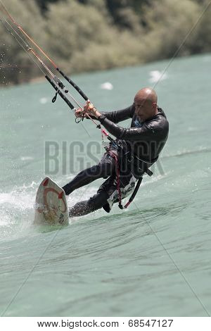 Professional  Kitesurfer Jumps Over The Water During Training On Lake Of Santa Croce
