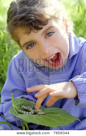 Kleine meisje Palying met Silkworm In handen