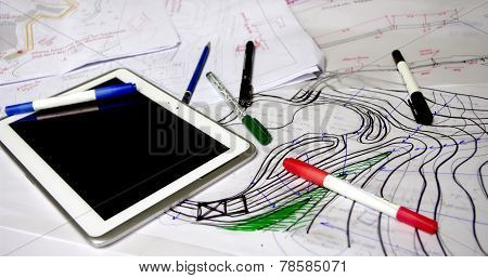 Architect Sketches With Papers, Markers, Pens And Tablet